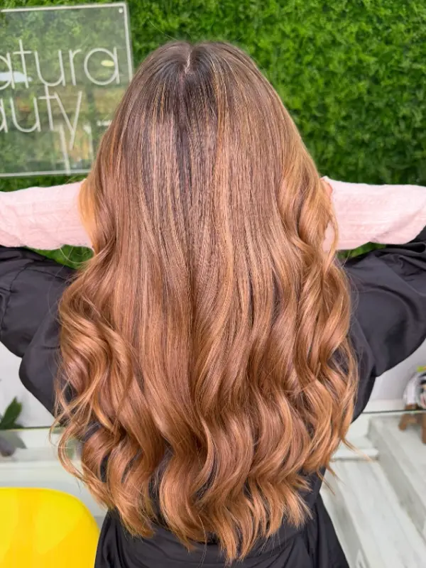 Melena larga en tono cobrizo con ondas, vista de espaldas